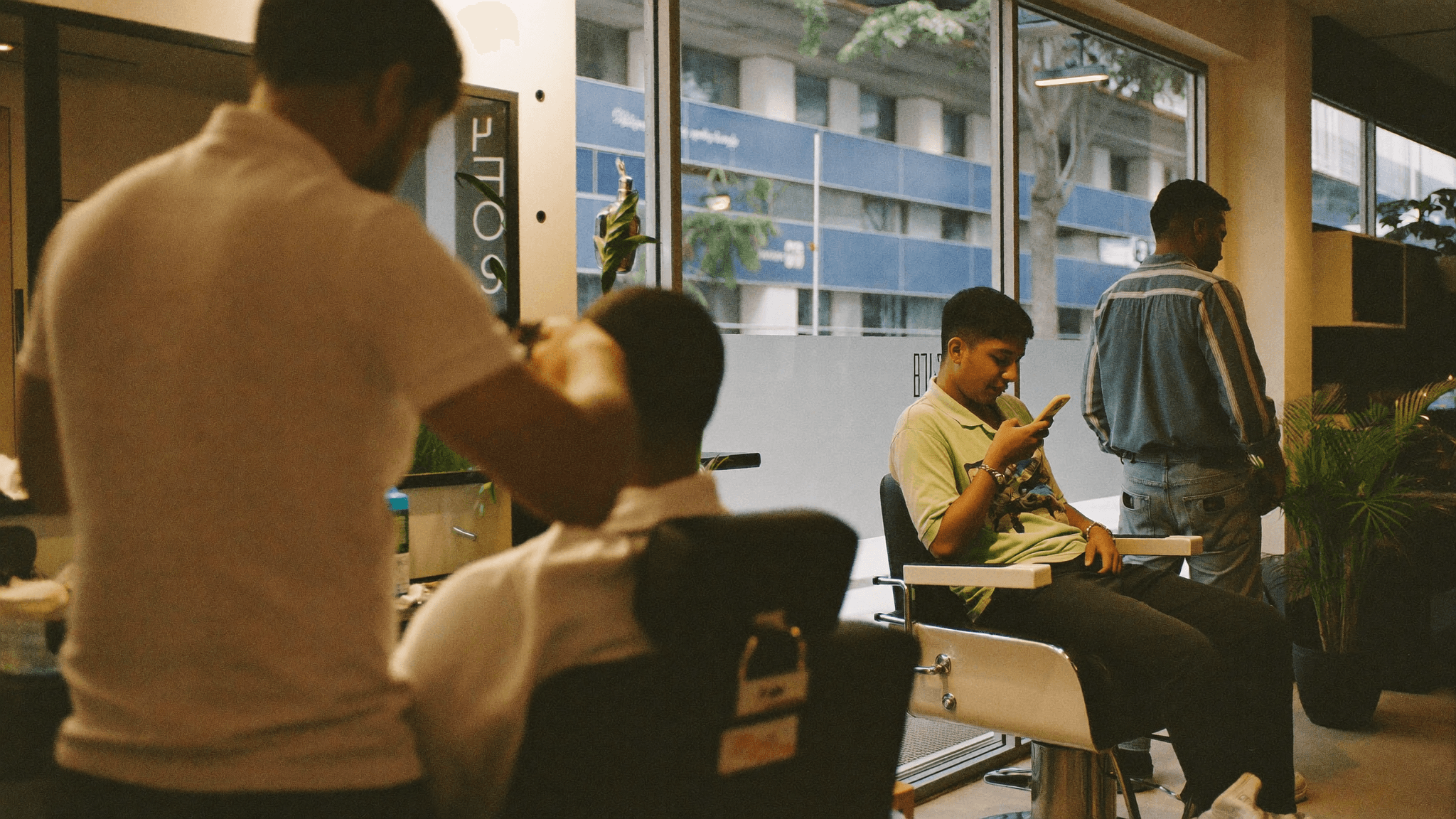 Barbeiro cortando o cabelo de um cliente em uma barbearia moderna e acolhedora