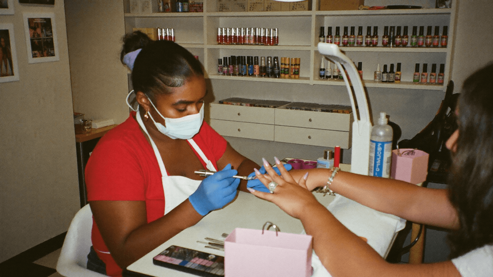Nail designer atendendo uma cliente em uma mesa de manicure organizada